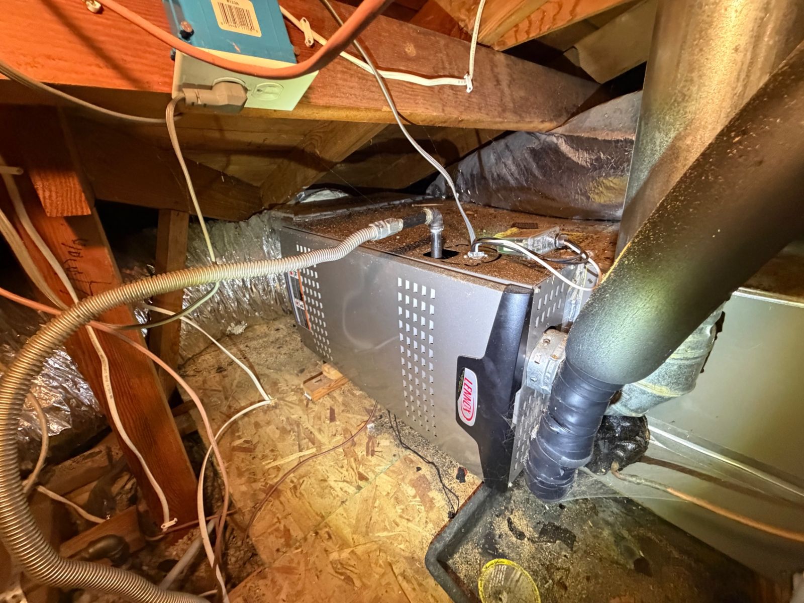 Attic furnace with ducts and wiring during an inspection